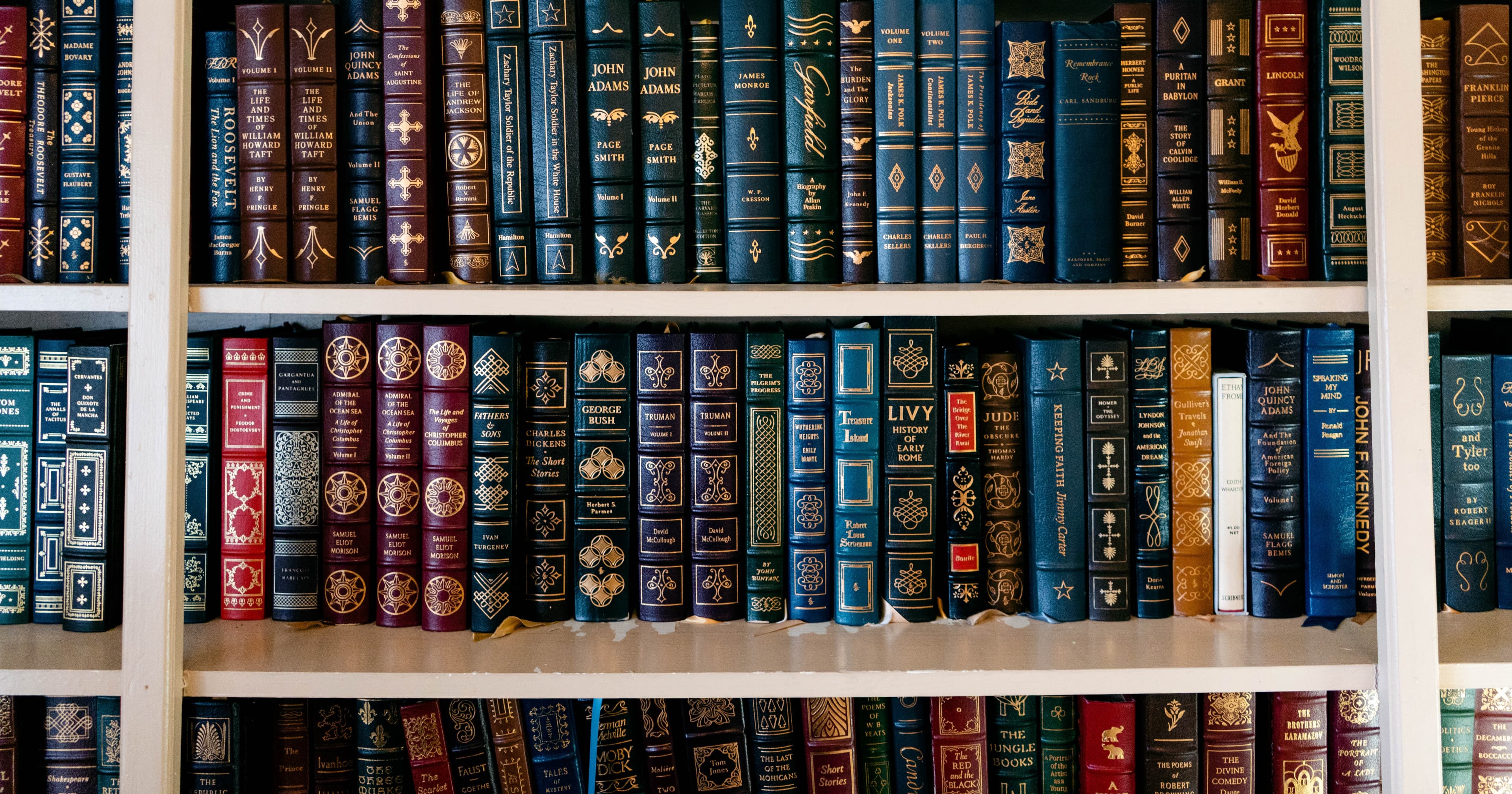 A close-up of a bookshelf filled with assorted leather-bound books in various colors.