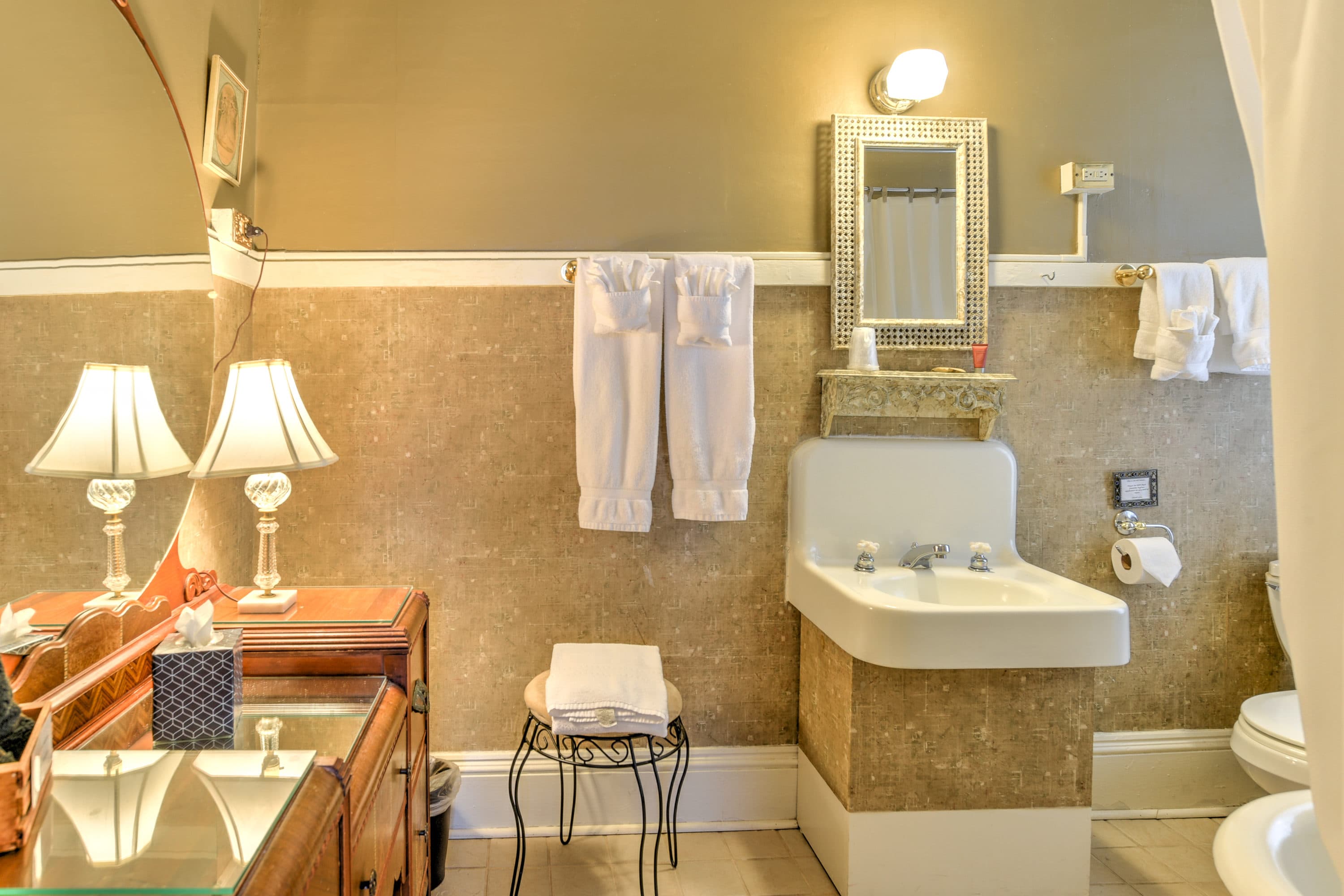 Bathroom features a large vanity, white sink, and claw-foot tub with wrap-around shower curtain.