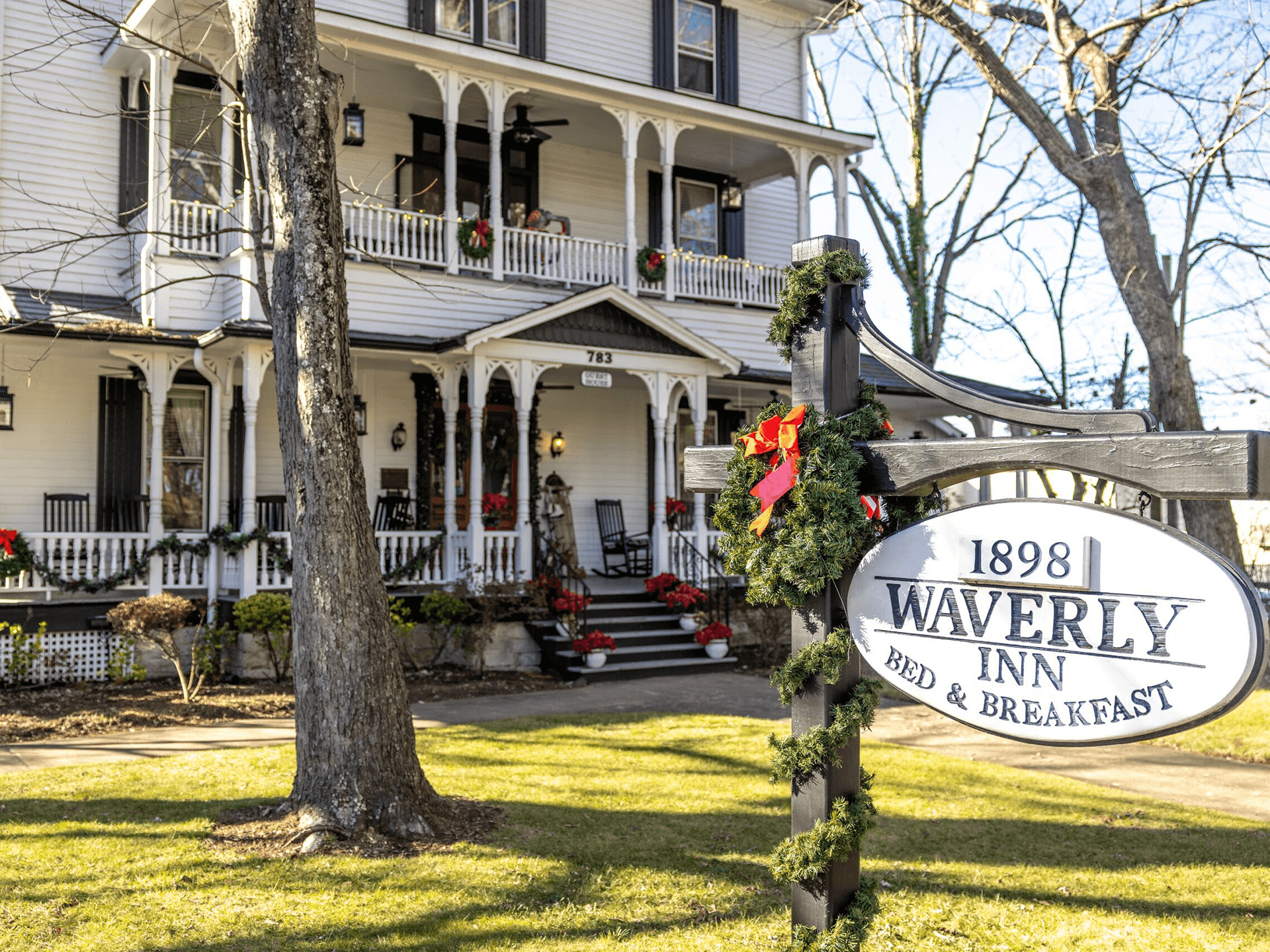 A charming bed and breakfast, the Waverly Inn, showcases festive decorations and a welcoming porch.